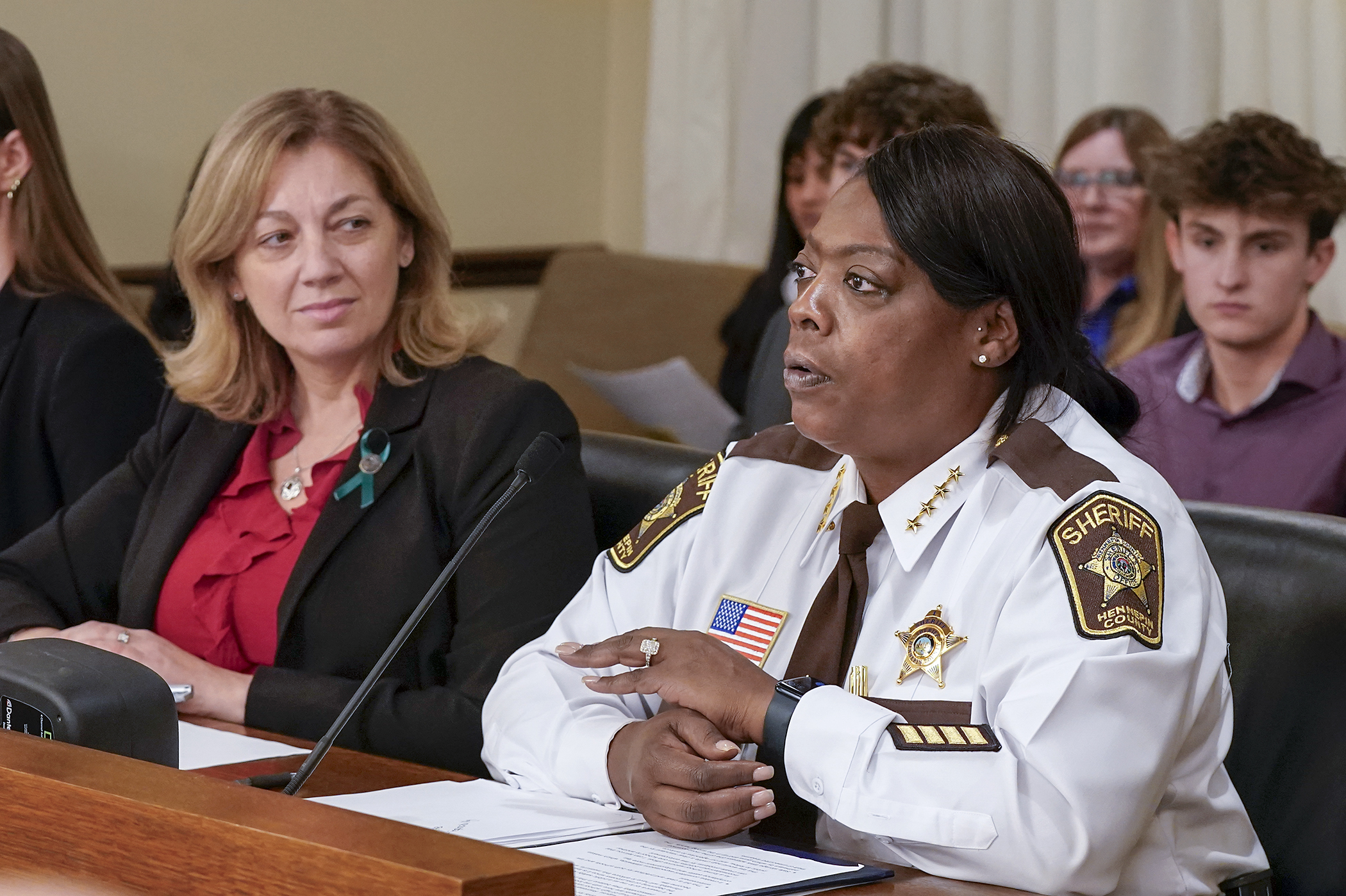 Hennepin County Sheriff Dawanna Witt testifies Feb. 25 in support of a bill sponsored by Rep. Julie Greene, left, to modify a statute that regulates the possession of firearms on school property. (Photo by Michele Jokinen)